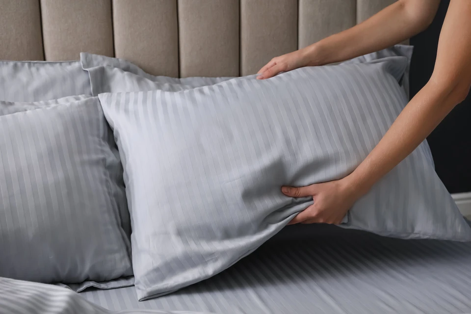 Pile de draps et d'oreiller propres sur fond blanc