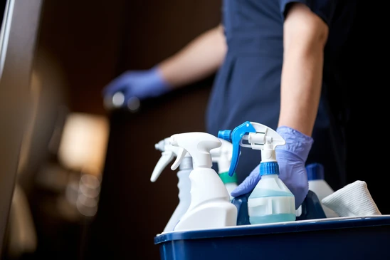 Scène d'entretien professionnel dans un bureau moderne avec employé en combinaison bleue effectuant le nettoyage du sol